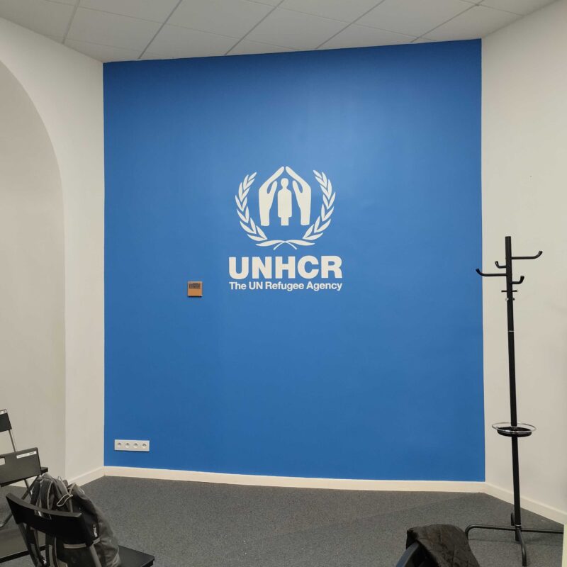 logo-organizacji-unhcr-wymalowane-recznie-na-niebieskim-tle